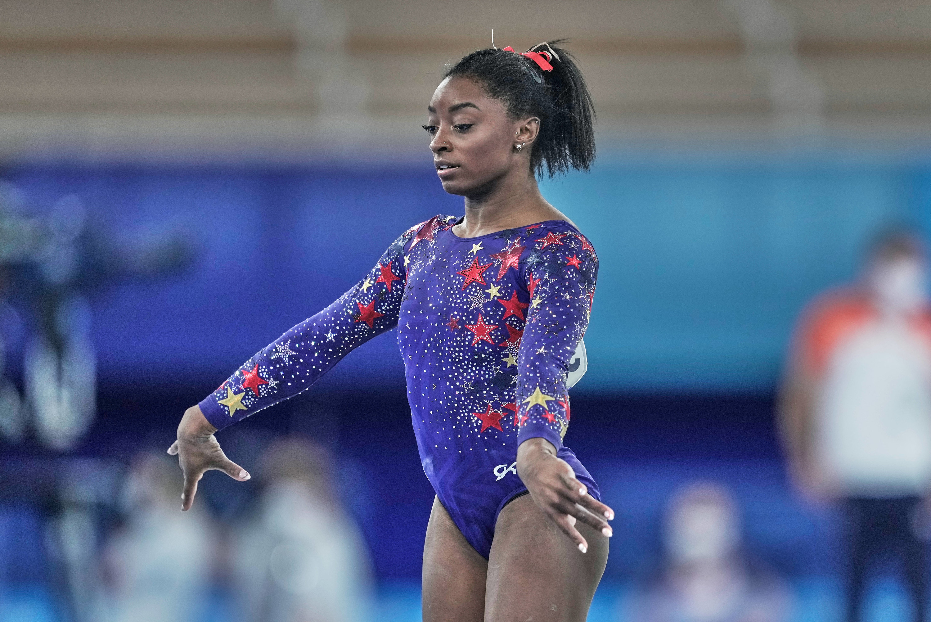 Simone Biles stands with her arms out near her sides during the artistic gymnastics final at the 2020 Olympics