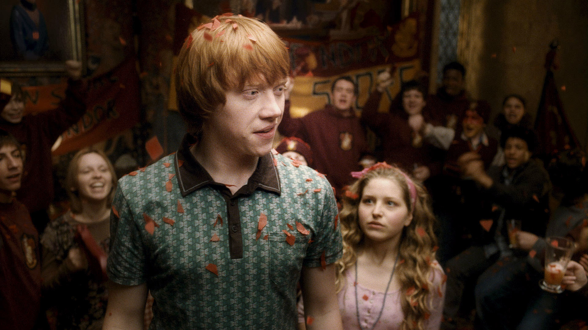 Ron Weasley stands in the foreground as Lavender Brown looks at him