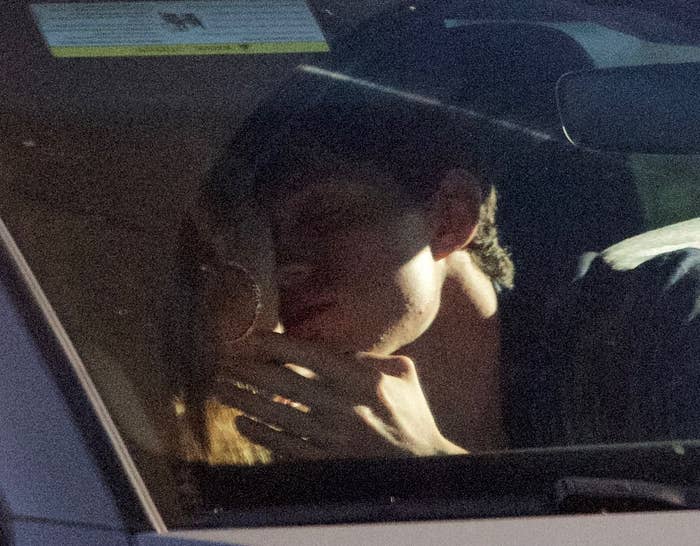 Tom holding Zendaya's face as he leans in for a kiss
