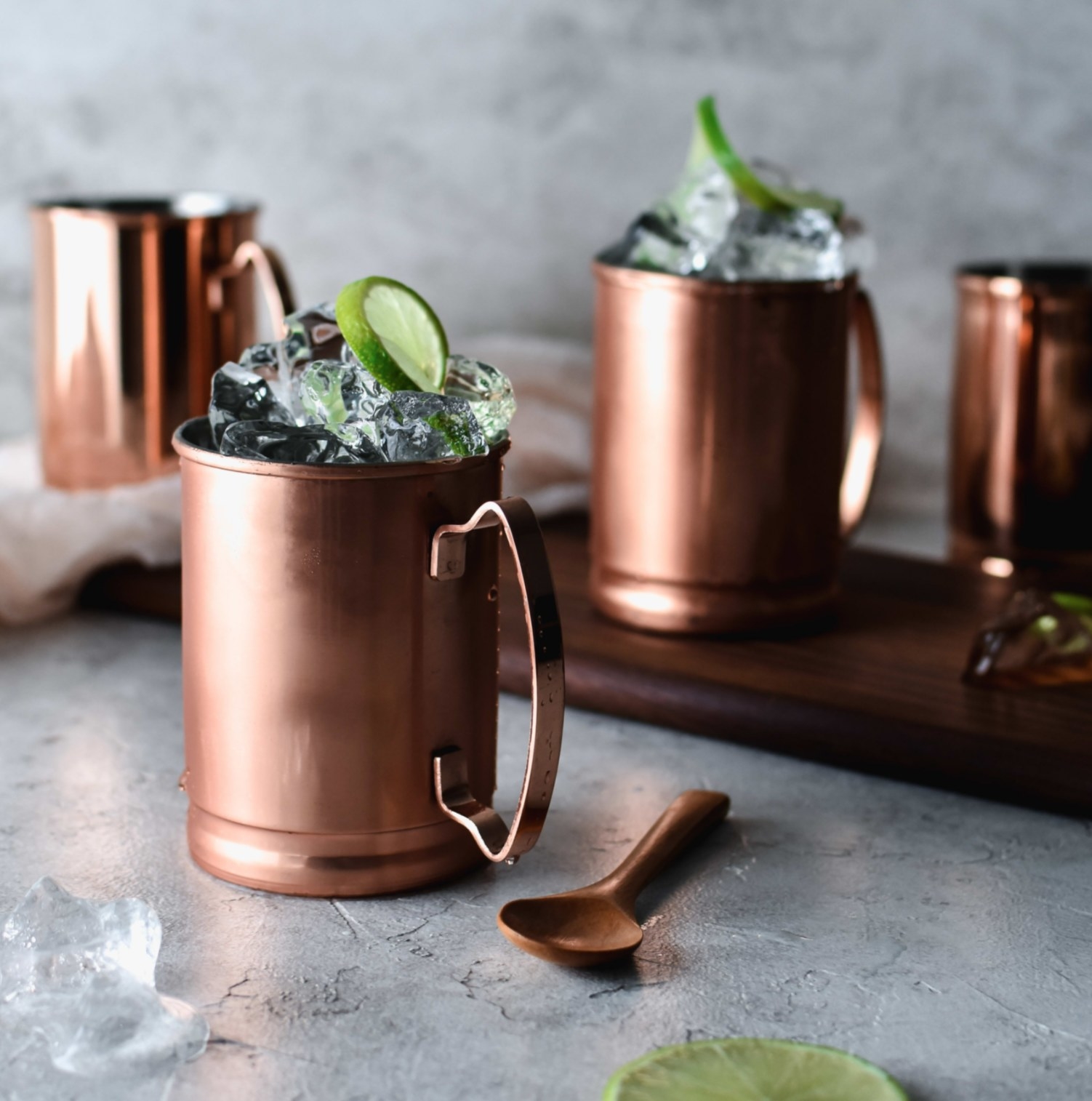 the copper mugs with ice and limes in them
