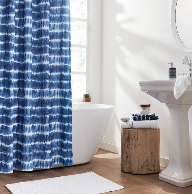 The blue and white tie dye shower curtain in a bathroom