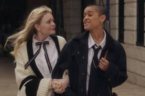 Audrey wears an oversized knit sweater over a blouse with a skinny tie and Julien wears a pinstripe button up shirt under a dark tie and a matching jacket
