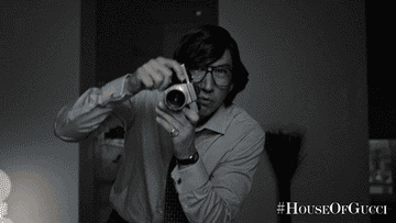 adam driver taking gaga&#x27;s picture in a scene from house of gucci