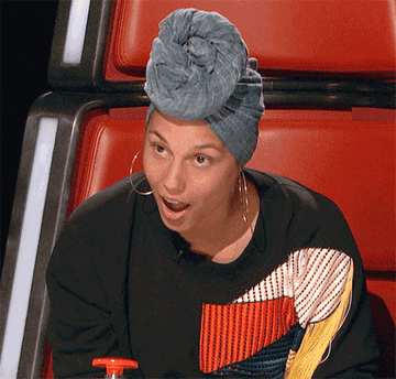 surprised alicia keys leaning forward in her chair