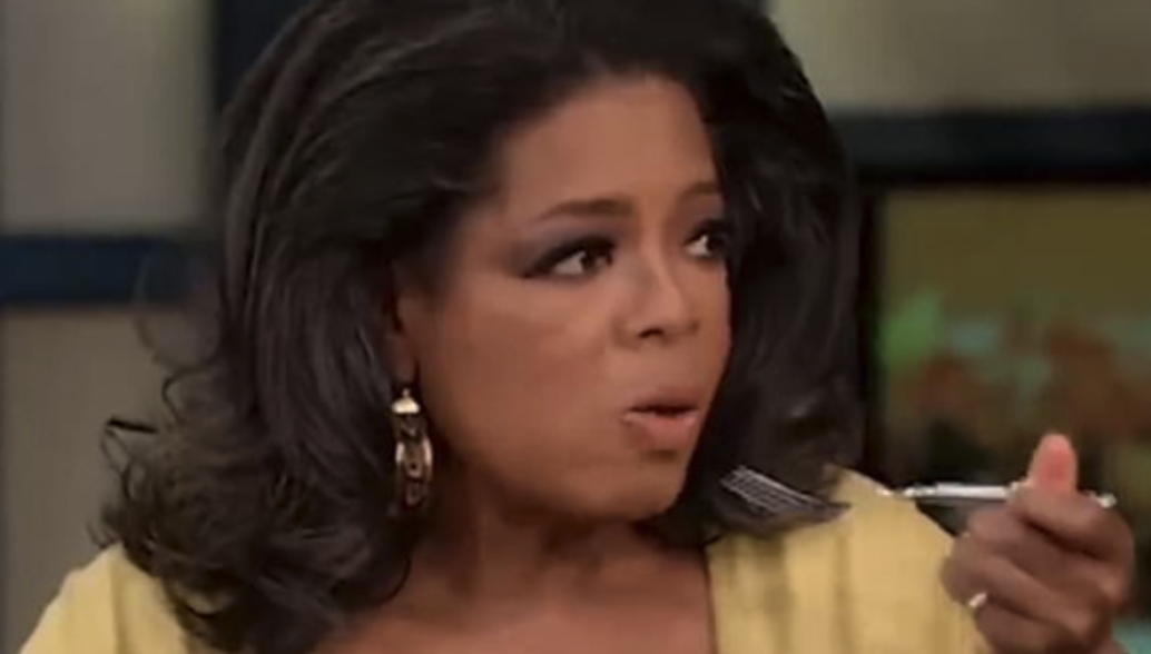 Oprah looking shocked with a fork in her hand