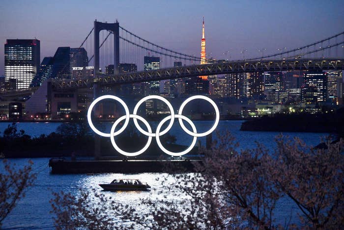 A boat sailing past an illuminated sculpture of the Olympic rings in Tokyo
