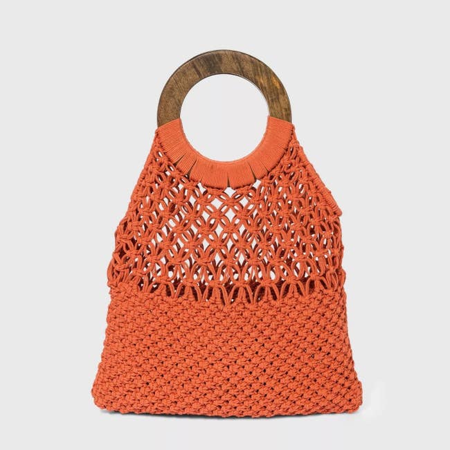 Orange purse with holes, and dark wooden handle