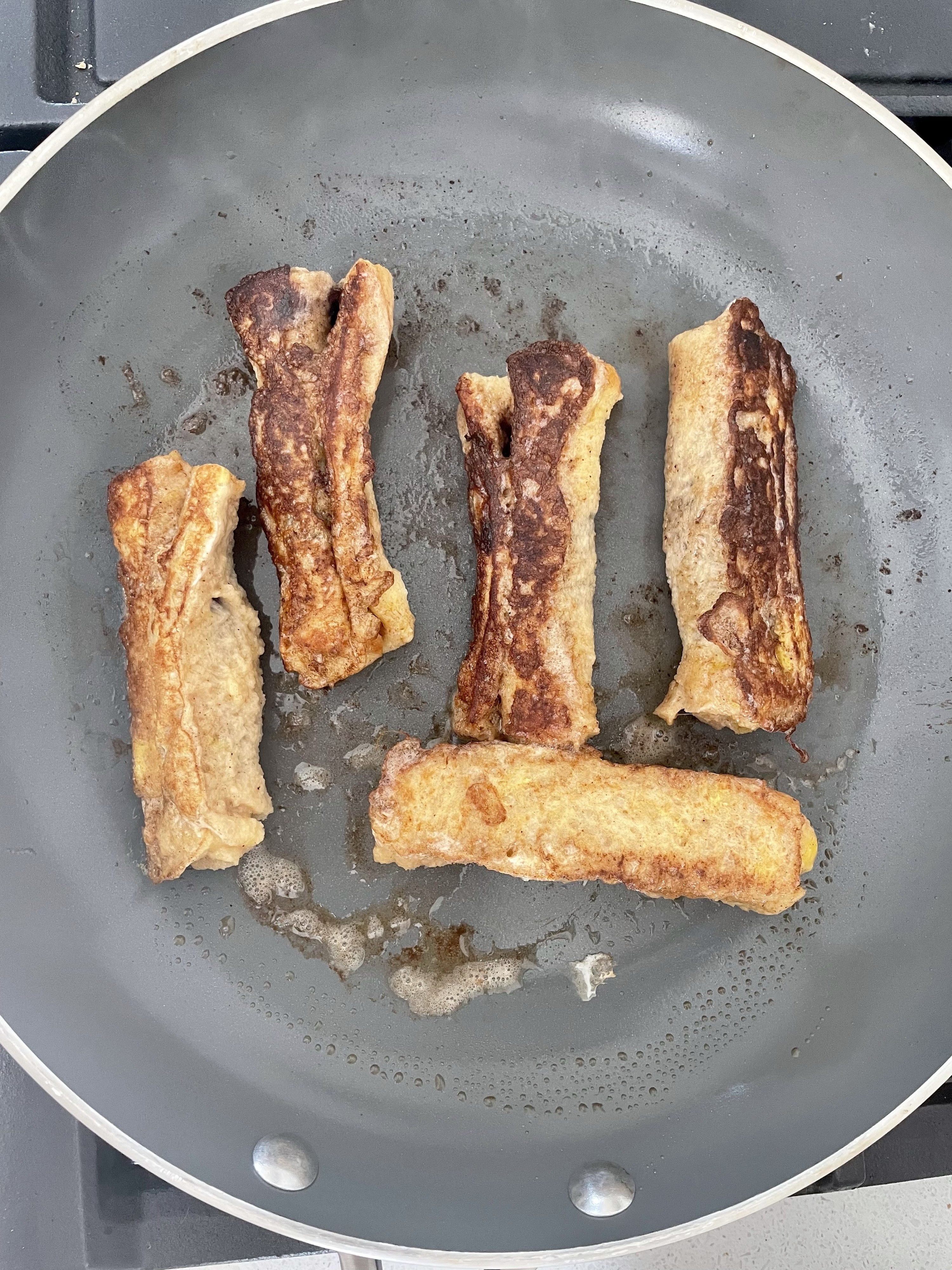 French toast roll ups cooking in the pan