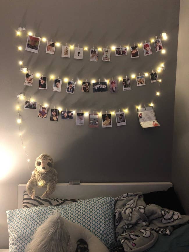 Reviewer's photo showing photos displayed with the clips and fairy lights in their child's bedroom