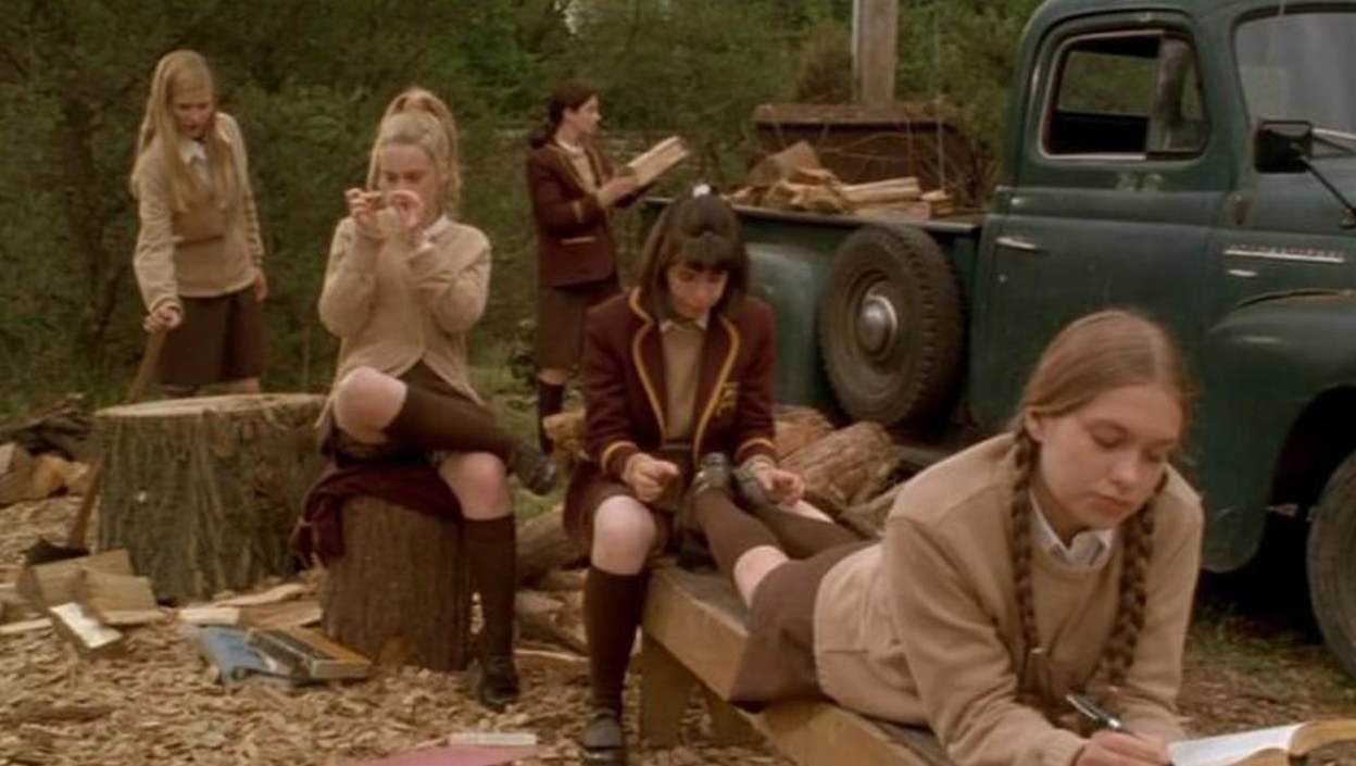 The girls of The Hairy Bird relax together around a wood chopping area