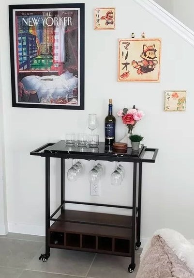 The bar cart with wine glasses and a wine bottle ready to be served