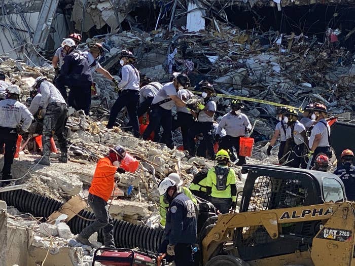 Rescue workers hand debris to one another in the rubble