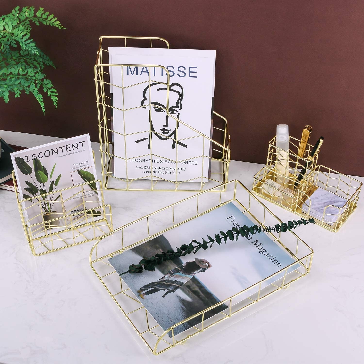 A metal magazine holder, A pencil holder, and a paper tray on a table
