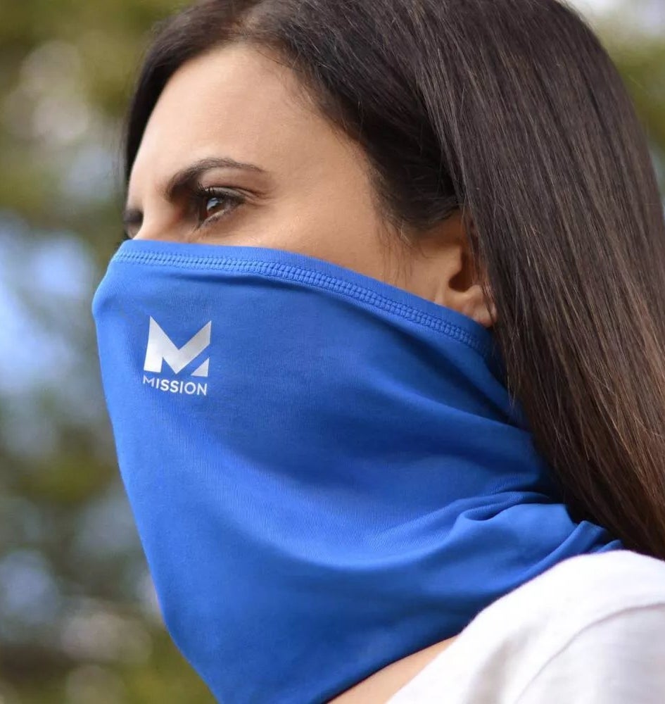 A model wearing the blue Mission gaiter as a face mask
