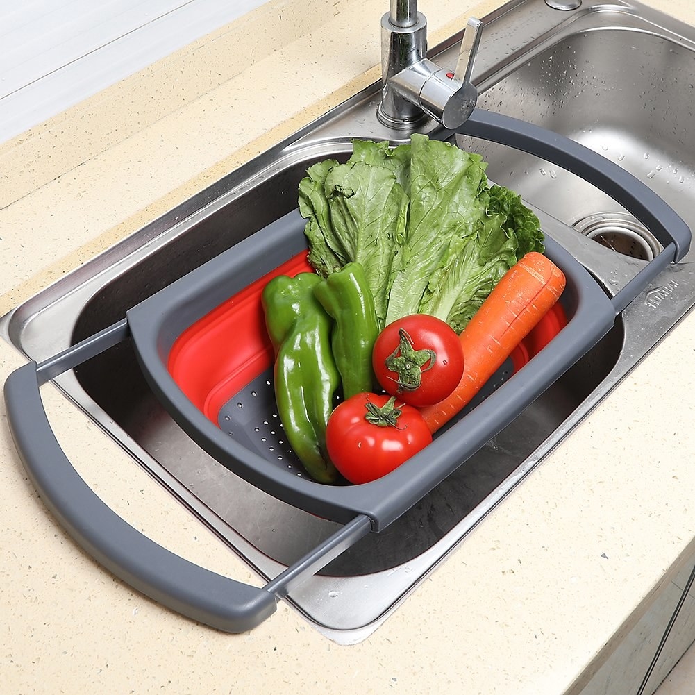 A colander with vegetables on it on a sink