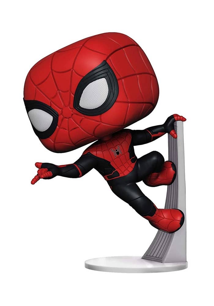 A bobblehead of Spiderman hanging off a ledge.