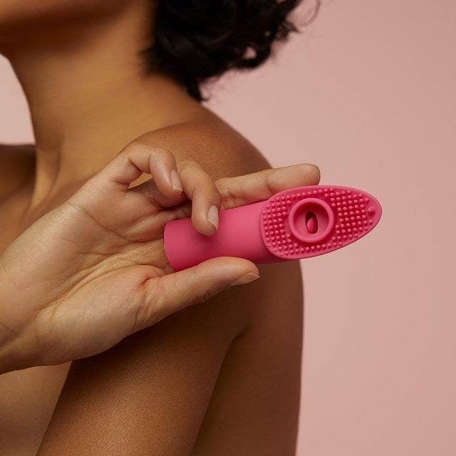 Model holding pink finger vibrator