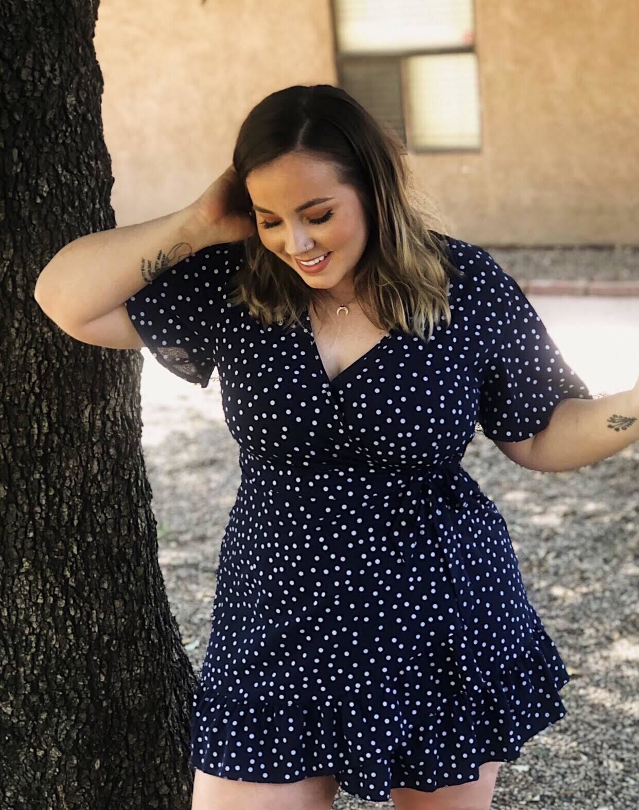 A reviewer looks flawless in the dress in black with white polka dots