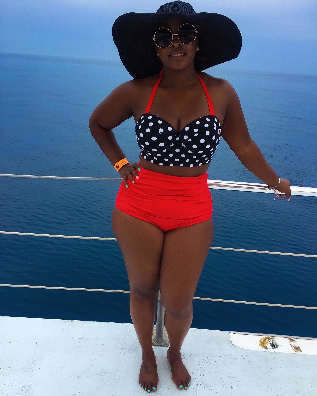 A reviewer looking absolutely gorgeous in the two-piece swimsuit; it has a polka dot bustier top and the bottoms are square-cut and reach above the belly button on this person