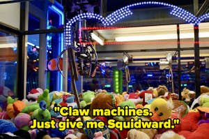 View from inside a claw machine just above a layer of toys with claw hanging over w text 'claw machines just give me Squidward'
