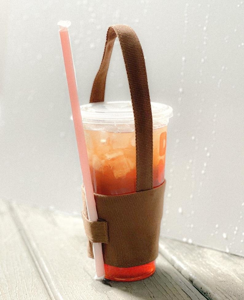 The coffee cup holder holding a drink and straw