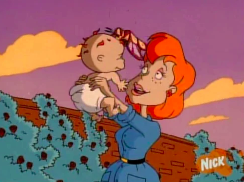 Melinda holding a baby Chuckie in the air