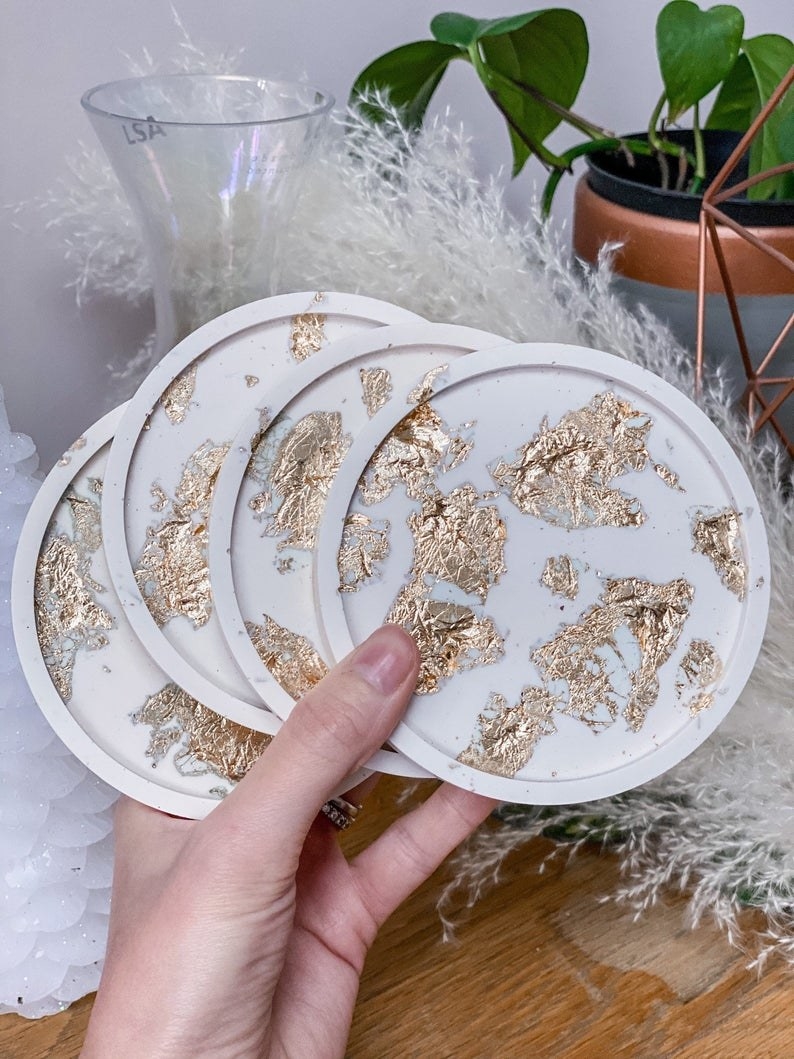 The white coasters with a gold flake design on them