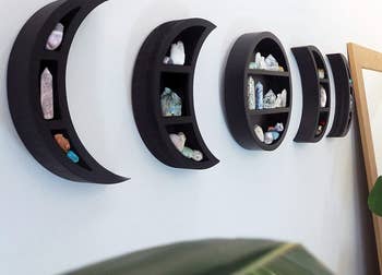 a closeup of the five-piece wall-mounted moon phase shelf set with crystals on each shelf