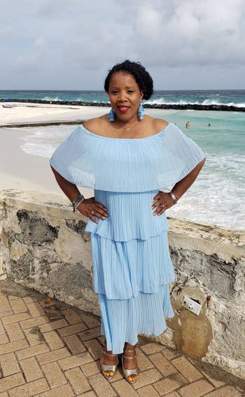 A reviewer wearing the midi dress, which is made up of four tiers, in light blue