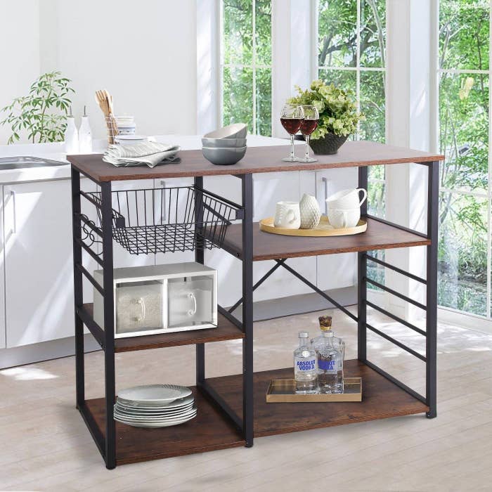 a black and wooden bakers rack with 5 racks and one wire basket