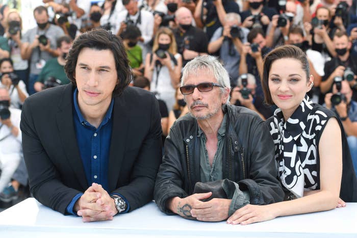 Adam Driver, Leos Carax, and Marion Cotillard are photographed together during the Cannes Film Festival