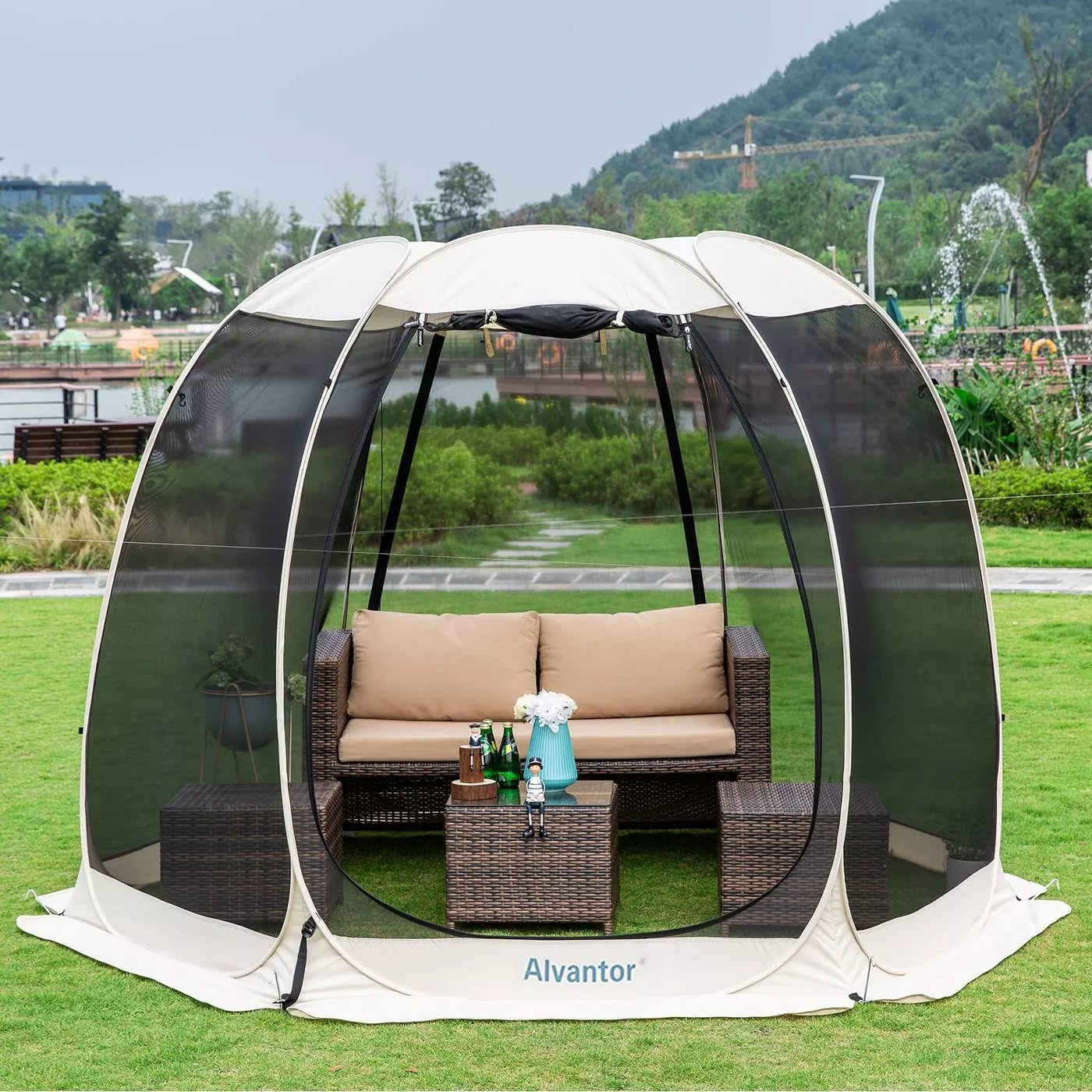 The pop-up gazebo tent is outside and says &quot;Alvantor&quot; and has porch furniture inside