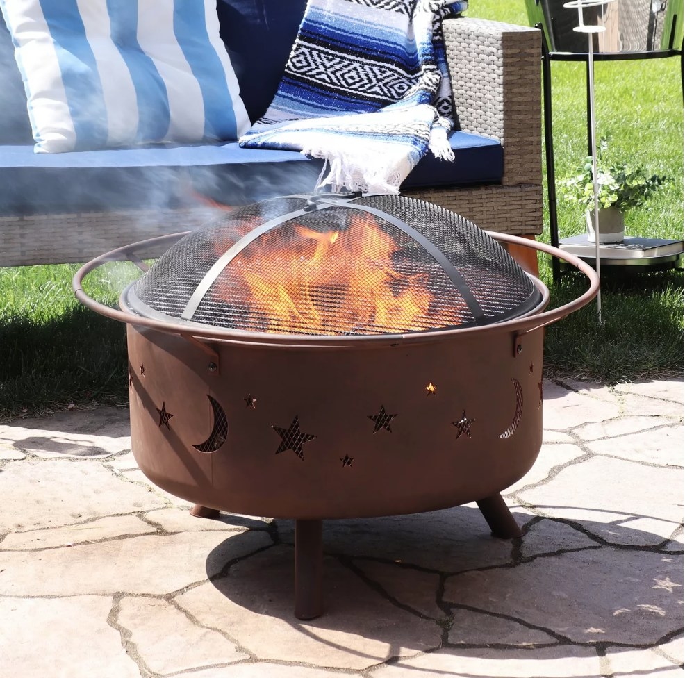 Round fire pit with moon and star shape slates on the side