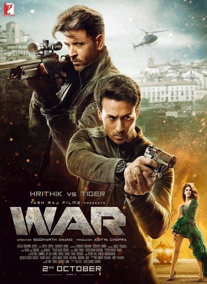 The poster of the movie war in which hrithik roshan and tiger shroff brandish guns while vaani kapoor&#x27;s character poses seductively