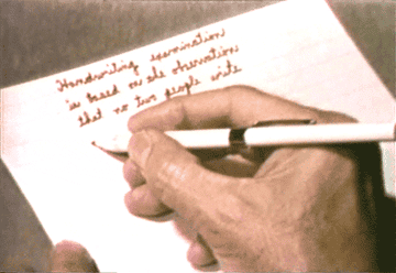 A hand writing a letter