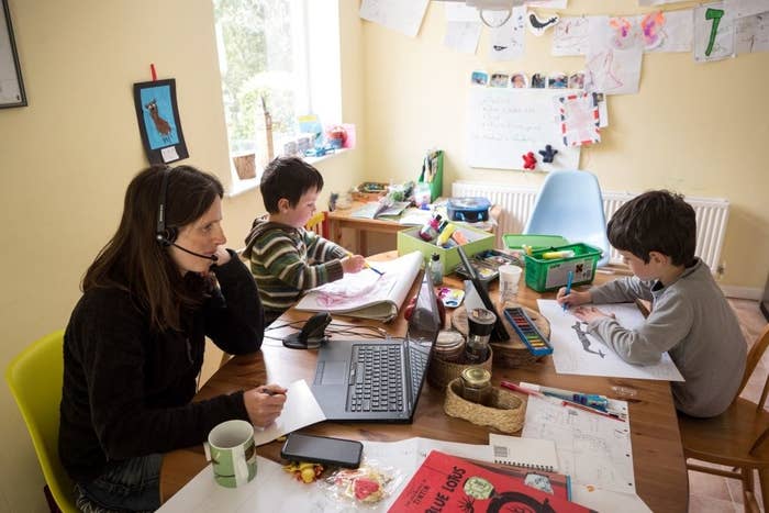 Woman working from home while watching two young children
