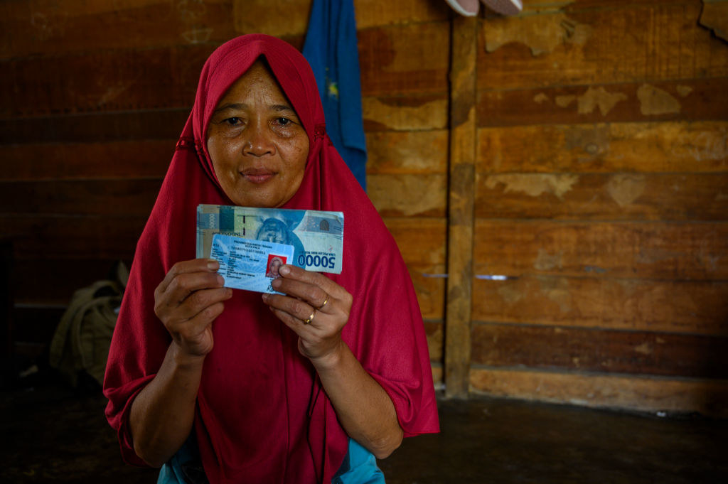 A resident shows the Cash Social Assistance (BST) money they just received at the Palu Post Office, Central Sulawesi Province, Indonesia on September 17, 2020.