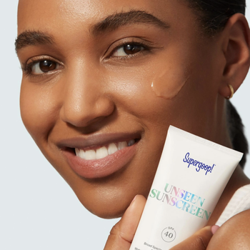 model with swatch of transparent sunscreen on her cheek 