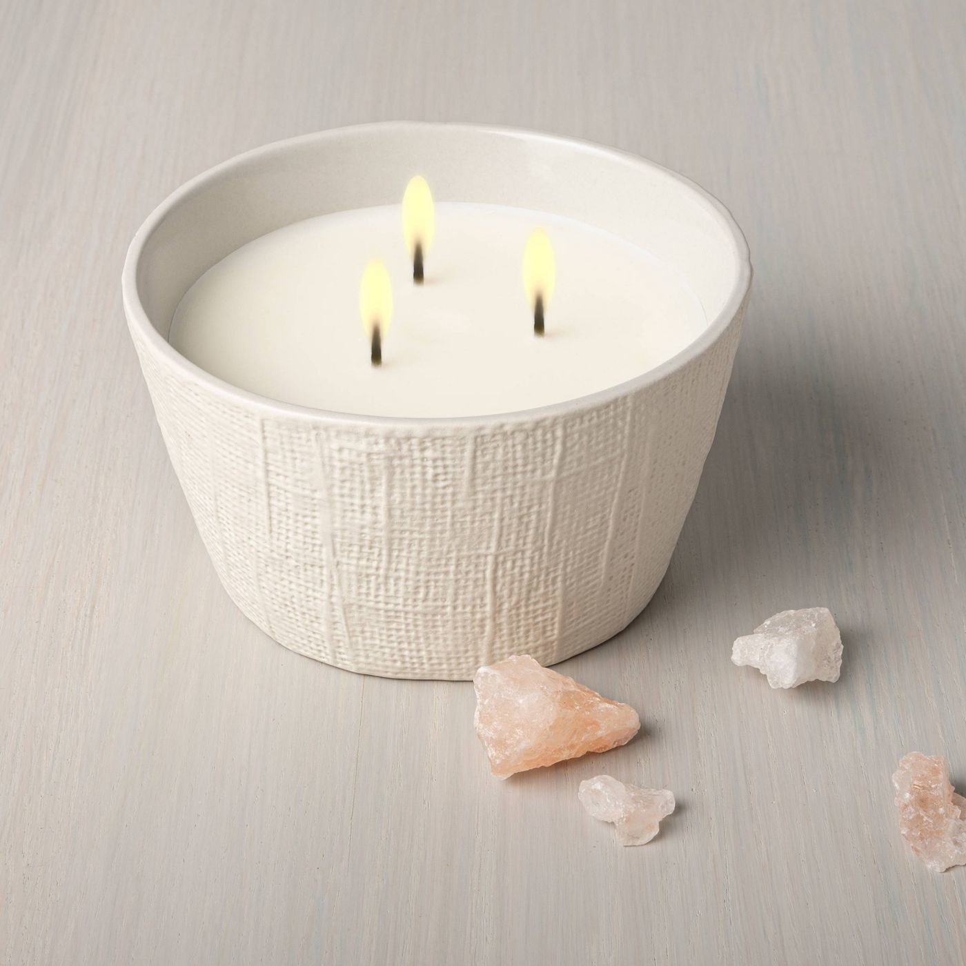 A large 3 wick candle in textured ceramic holder