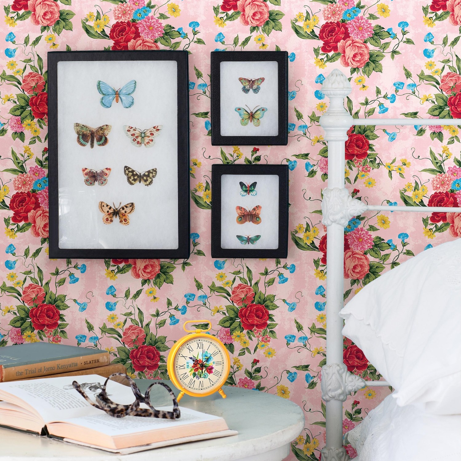 The pink, red, yellow, and blue floral wallpaper in a bedroom