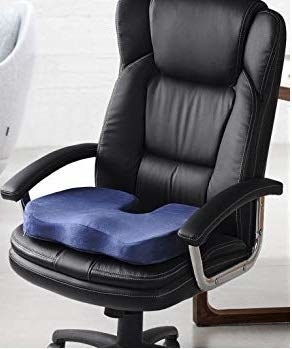 A navy blue memory foam cushion placed on a black office chair.