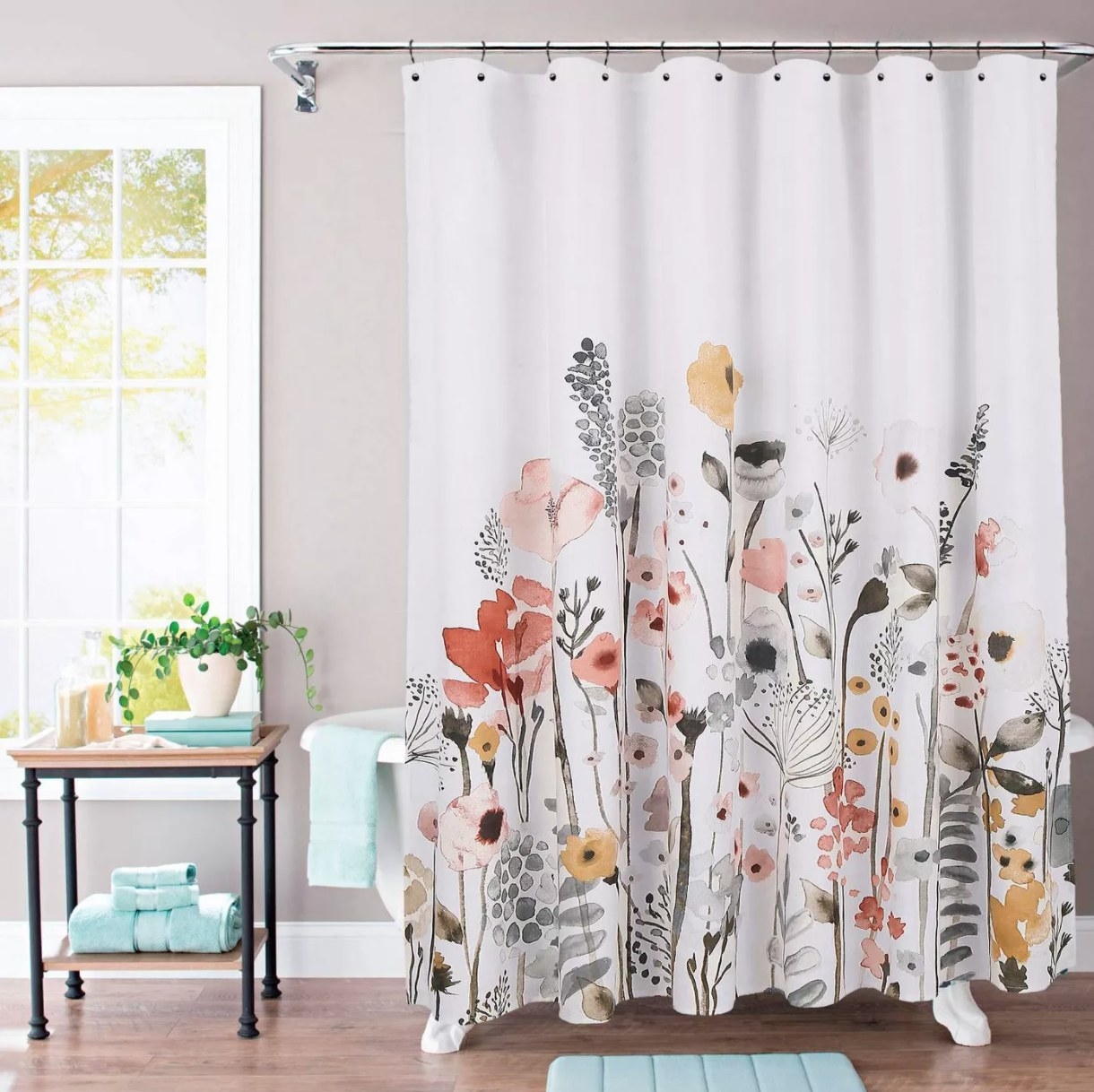 A white shower curtain with gray, pink, and muted yellow design