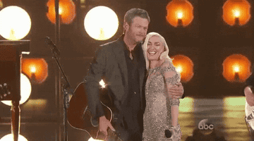 Blake Shelton and Gwen Stefani hug on stage at the Billboard Music Awards