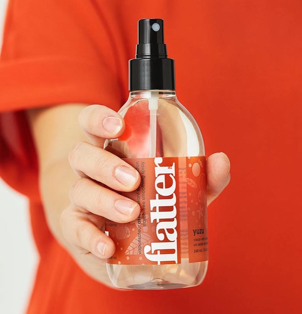 A person holding the bottle of  wrinkle releaser
