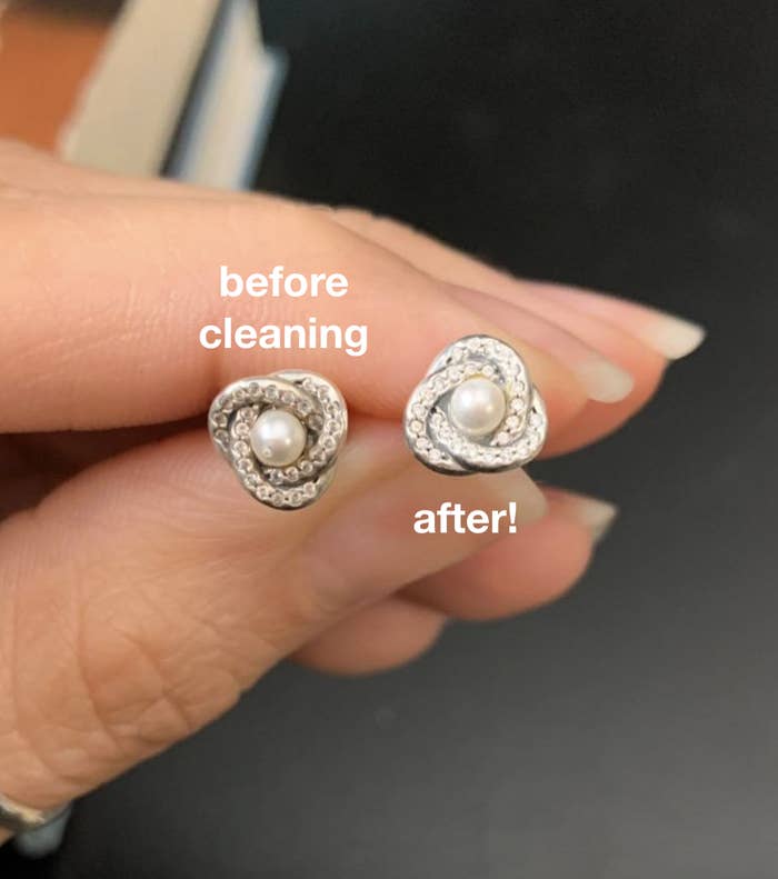 reviewer holding earrings with one cleaned with the pen and much shinier and cleaner