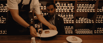 Aziz Ansari being served fancy food in Italy.