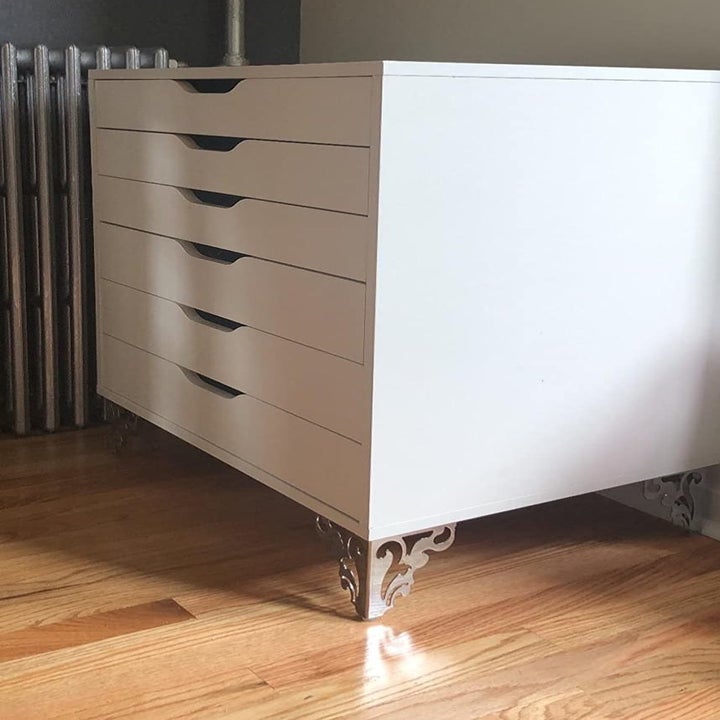 the silver metal furniture legs on a white dresser