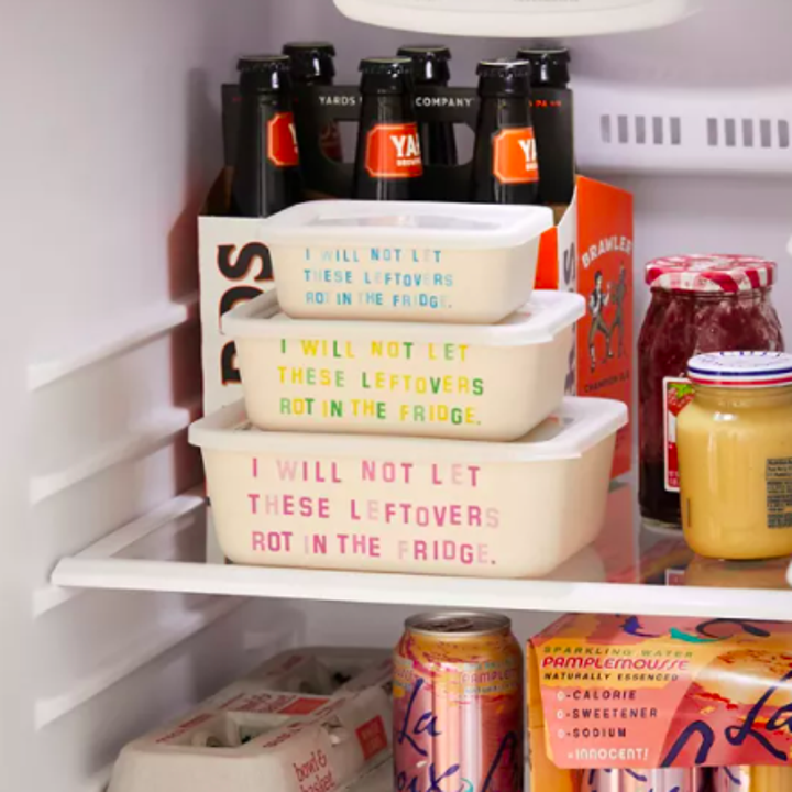 A trio of cute food containers stacked neatly in a fridge