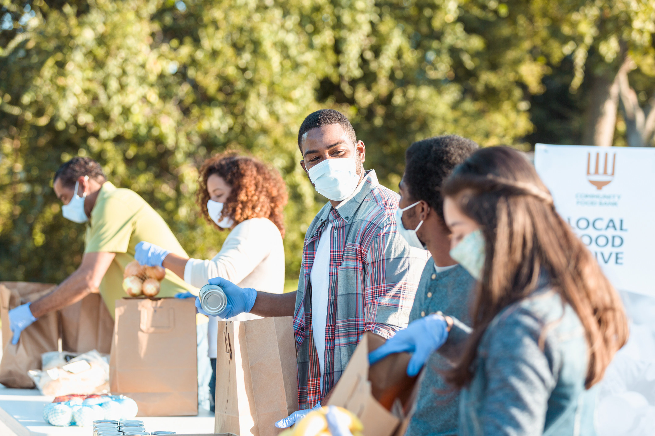 group of masked people working in a foodbank