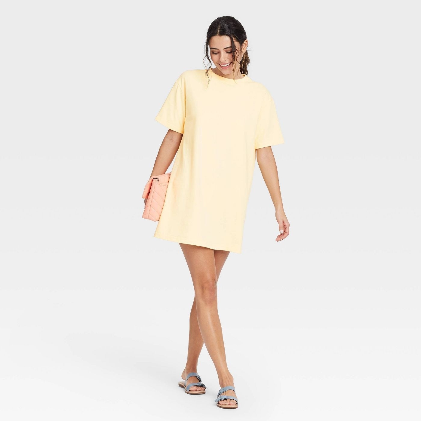 A model wearing a light yellow t shirt dress